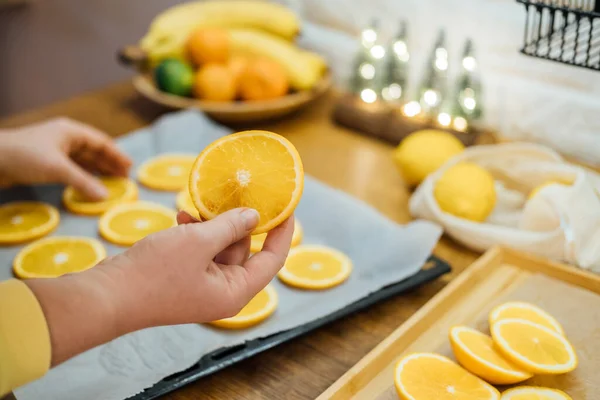 How to Dry Orange Slices for Eco friendly zero waste Holiday Decor. Close up Process of Drying Orange Slices in Oven. Woman cutting slices of orange and citrus fruits for drying in oven in kitchen.