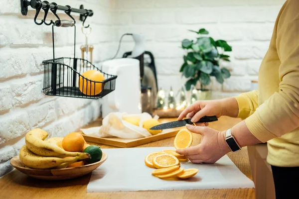 如何在假日装饰中烘干橙片 烘干烤箱中橙片的工艺 妇女切片橙子和柑橘类水果 放在自家厨房的烤箱里烘干 — 图库照片