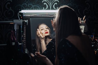 Yeni yıl arifesi, tatil makyajı fikirleri. Güzel genç bayan, parlak akşam makyajı kırmızı dudaklar gece partisine hazırlanıyor. Tatil eğlencesi Mutlu yıllar yeni yıl partisi kutlaması