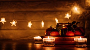 Yılbaşı mumları akşam karanlık arka plan web afişi. Festival sezonu için turunçgil mumu ve mutfak ahşap masasında sulu portakallar. Yeni Noel Noel Mumları Kişiselleştirilmiş Mum kavanozu