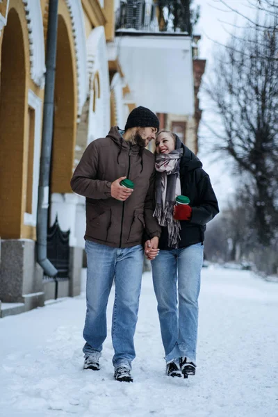 Winter Date Ideas to Cozy Up. Cheap First-Date Ideas for Winter Love dating outdoors. Cold season dates for couples. Young couple in love hugging and kissing in winter street and park