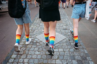 Cinsel Oryantasyon ve Cinsiyet Kimliği. LGBT Gençliği. LGBTQ Teens 'ten geliyorum. Sokakta yürüyen LGBTQ gökkuşağı çoraplı gençlerin yüzsüz portresi. Varşova, Polonya, 25 Haziran 2022.