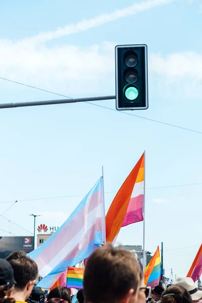 stock image Green traffic light and LGBT rainbow flags being waved in the air at a pride event. Wave LGBTQ gay pride flags. Equality Parade. Warsaw, Poland, June 25, 2022.