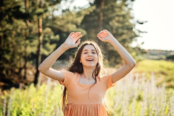 Positive emotions like happiness, excitement, joy, hope, and inspiration is vital for happy and healthy life. Outdoor portrait of happy smiling young woman in nature background.