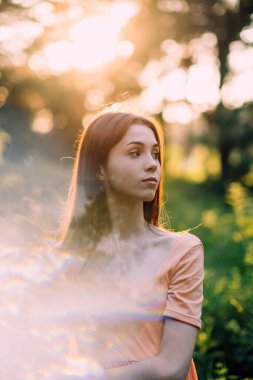 Bütünsel ve bütünleştirici tıp. Zihin-Vücut Terapileri, rahatlama teknikleri. Doğa arka planında yansıması olan genç bir kadının açık hava portresi.