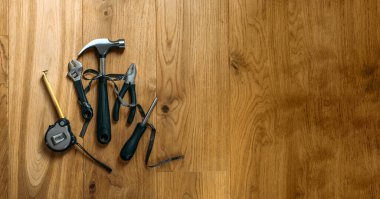 Ahşap arka planda farklı inşaat aletleri olan mutlu işçi bayrağı. Ahşap arka planda inşaat ve imalat araçları. İşçi Bayramı arkaplan kavramı