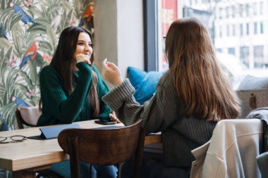 Arkadaşlar dijital detoks. İki arkadaş kafede kahveyle yüz yüze konuşmaktan zevk alır, akıllı telefonların dikkatini dağıtmadan kişisel etkileşime girerek dijital detoks.
