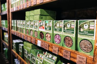 Marketteki raflarda bitki çayı çeşitleri. Organik ürünler mağazasının raflarında doğal sağlık ürünleriyle ilgilenen müşteriler için düzgünce sergilenen çeşitli organik bitkisel çaylar.
