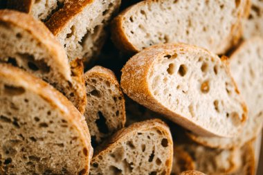Taze dilimlenmiş kepekli ekmekle dolu ahşap bir kase. Sağlıklı beslenmek için ideal. Esnaf ekmeği Düşük tuz, şeker ve yağ
