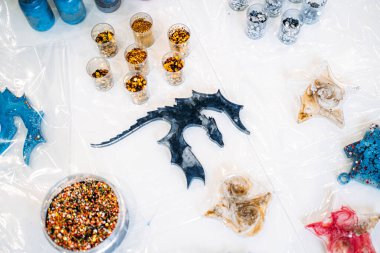 Eldiven takan, epoksi reçine sanat eserine titizlikle pigmentler ekleyen bir kişinin eldiven giydiği yakın plan..