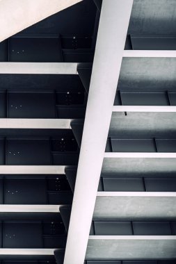 Endüstriyel tasarımı vurgulayan, kesişen kirişleri ve geometrik desenleri olan modern çelik yapının soyut görüntüsü.