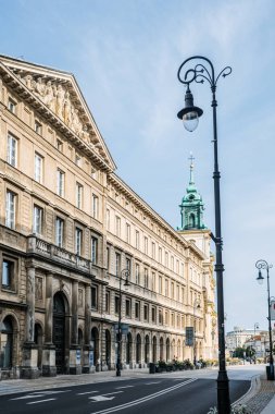 Varşova 'daki Nowy Swiat Caddesi' ndeki tarihi binanın ön cephesine yakından bakın. Süslü mimari detaylar, büyük ahşap kapılar ve heykel kabartmaları yer alıyor..