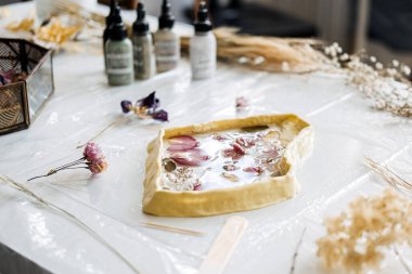 Sıkıştırılmış çiçek ve yaprakların günlük malzemelerin nasıl güzel DIY sanat eserlerine dönüştürülebileceğini vurgulayan reçine kalıbına yakın plan..