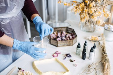 Koruyucu eldiven ve önlük takan biri DIY projesi için temiz bir kaba reçine karıştırıyor. Çevre dostu ev dekorasyonuna odaklan.