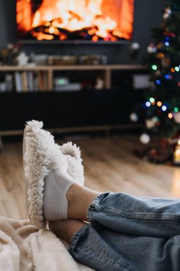 Yumuşak ışıklandırma ve şenlikli süslemelerle Noel ağacının yanında rahat terliklerle dinleniyorlar. Bayram kızlığını ve sıcak ev konforunu kucaklamak