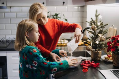 Anne ve kız Noel hediyelerini birlikte pişiriyorlar, bir festival mutfağında, aile geleneklerini kutluyorlar, Noel arifesi pişirmeleri, ve birlikte tatilin sıcaklığını..