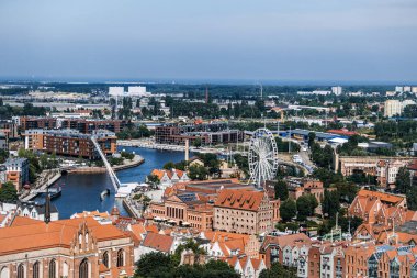 Dönme dolaplı Gdansk 'ın panoramik manzarası, tarihi binalar ve nehir manzarası. Miras ve modernliğin dinamik karışımı. Gdansk, Polonya - 19 Mayıs 2024.