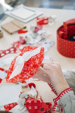 Kırmızı ve beyaz kumaşlı el yapımı tatil dekoru. Şenlikli kültürel el sanatları ve Slav kaynaklı dikiş gelenekleri sergileniyor