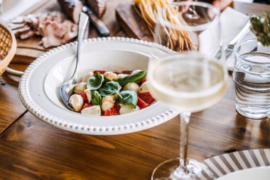 Caprese salatası, beyaz şarap ve taze malzemelerle kırsal yemek düzeni, çiftlikten sofraya yemek ve doğal zarafet..