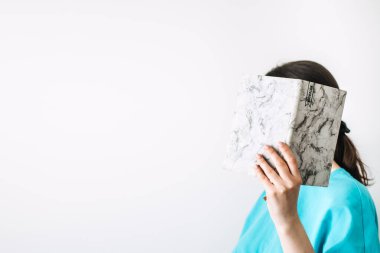 Minimalist bir ortamda elinde defterlerle gülümseyen kadın. Modern günlük uygulamalarıyla yazma, yaratıcı ifade ve kişisel gelişim yoluyla öz-yansıma