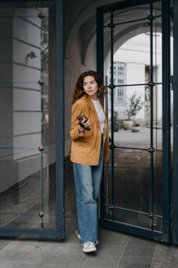 Gülümseyen milenyum profesyonel seyir hayatı elinde telefonla. Dijital güçlendirme, gelişigüzel stil ve teknolojik etkinleştirilmiş rutinler..