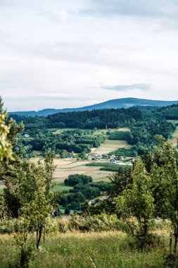 Tarlaları ekili kırsal vadi, dağınık evler ve yüksek bir çayırdan görünen ağaçlarla çevrili tepeler. Kırsal tatiller, tarım turizmi merkezleri, kırsal girdap, manzara huzuru.