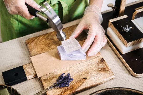 El yapımı lavanta sabununa damgalamak için metal bir damga kullanıyor. Konular arasında ürün kişiselleştirmesi, sürdürülebilir cilt bakımı, el yapımı kimlik yer alıyor. Yüksek kalite fotoğraf
