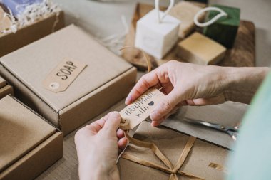 El yapımı sabun etiketini, el yapımı deri kalıplarının yanında bir Kraft hediye kutusuna yapıştırır. Dikkatli el yapımı, etik girişimcilik, yavaş yapılan, amaca yönelik bir iş. Yüksek kalite fotoğraf