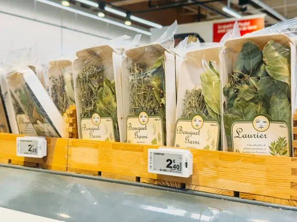 Dijital fiyat etiketleriyle süpermarket rafında sergilenen defne yaprakları ve kekik gibi önceden paketlenmiş Fransız otları. Lyon, Fransa - 19 Ağustos 2025. Yüksek kalite fotoğraf