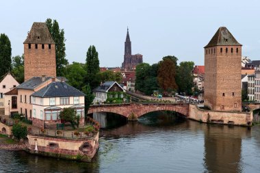 Tarihsel Ponts Couverts kuleleri ve arkasında Strasbourg Katedrali olan III Nehri üzerindeki köprü. Strasbourg, Fransa - 19 Ağustos 2025. Yüksek kalite fotoğraf
