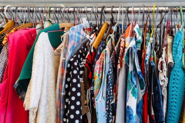 İkinci el giyim mağazasında sergilenen canlı renkli ve renkli bir elbise askısı. Bilinçli moda, sevilen kıyafetler, ucuz moda, sürdürülebilir gardırop. Yüksek kalite fotoğraf