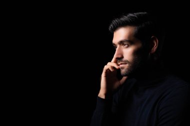 Düşünceli, genç sakallı yakışıklı adam portresi çekici sakallı, kendine güvenen, boş alana bakan, karanlık odada düşünen zeki adam.