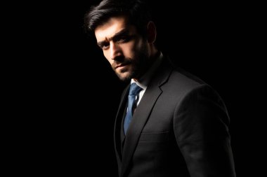 Lider başarılı iş adamı siyah arka planda takım elbiseli iş adamı kameraya özgüvenle bakıyor beyaz yakalı genç adam resmi takım elbise giyiyor yakışıklı adam profesyonel