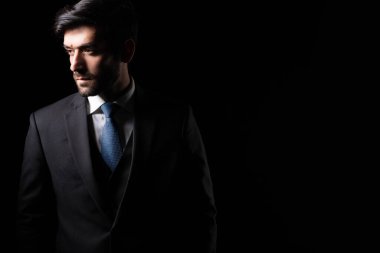 Lider başarılı, kendine güveni tam, iş adamı, siyah arka planda iş adamı, takım elbiseli, fotokopi odasına bakan, kendine güveni tam genç iş adamı, resmi takım elbiseli, yakışıklı, profesyonel.