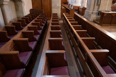 Empty wooden pews or chairs inside Gothic, medieval church in Europe. Wide angle, no people.