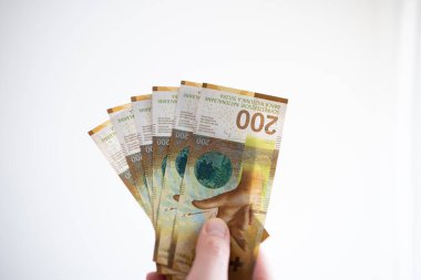 200 İsviçre frangı banknot tutan bir erkek. Stüdyoyu kapatın.
