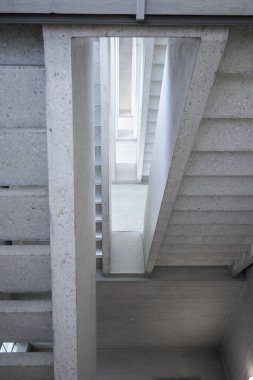 Boş bir kamu binasının koridorundaki beton merdivenler. Modern mimari, parlak iç mekan, insan yok..