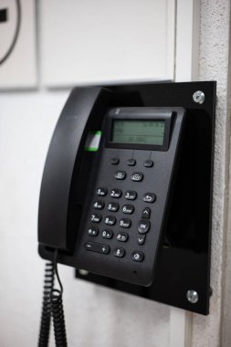 Duvara monte edilmiş dijital kablo telefonu, seçici odak, insan yok.
