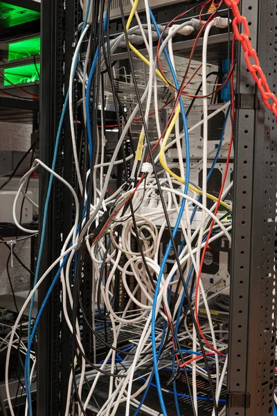 stock image Messy tangled electric cables connecting to industrial lab devices on a rack, no people