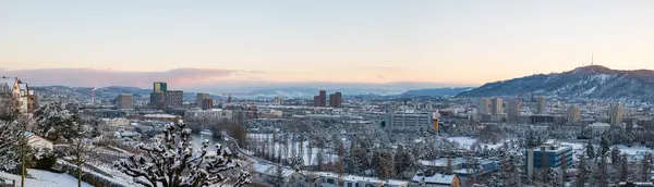 Snow covered Zurich city. Top view panorama, rooftop POV, sunset sky, no people