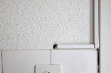 Mutfak duvarında beyaz plastik elektrik kablosu kapakları var. Yakın çekim, insan yok..