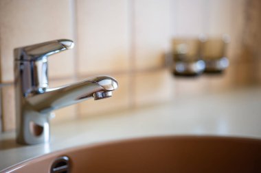 Gümüş, paslanmaz çelik banyo musluğu. Yakın çekim, sığ alan derinliği, insan yok..