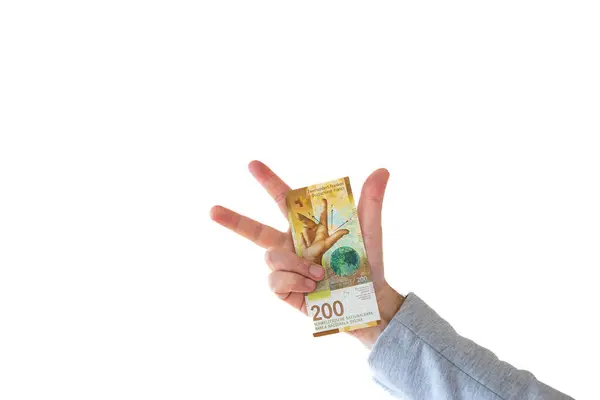 stock image One 200 Swiss francs cash banknote or bill held by Caucasian male hand. Close up studio shot, white background.