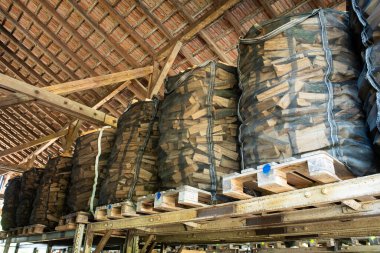 Palet bir ahırda depolanmış ve paketlenmiş odun yığınları, insan yok..