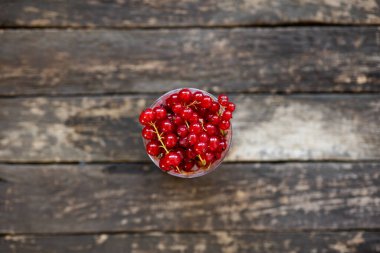 Ahşap zemin üzerinde bir bardakta taze üzümlü üzümler..
