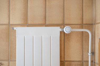 Ev radyatörü ve termostat, duvar monte edilmiş, insan yok..