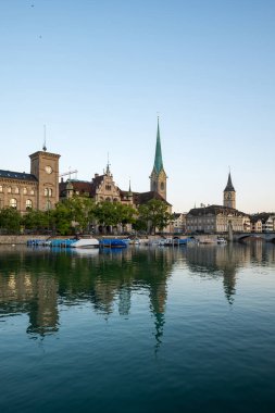 Zürih şehir merkezi, İsviçre. Limmat, Fraumunster ve Saint Peter kilise kulelerinin Riverside manzarası. Güneşli bir yaz günü, tekneler rıhtıma yanaştı..