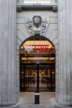 28-08-2024 Zürih, İsviçre. Bahnhofstrasse genel merkezindeki UBS banka binasının girişi. Taş kemer mimarisi, cam kapılar, kemerin üstünde tip ve logo, insan yok..