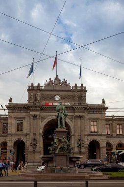 03-09-2024 Zürih, İsviçre. Zürih ana tren istasyonu ya da Hauptbahnhof bulutlu bir yaz gününde ünlü Bahnhofstrasse 'de görüldüğü gibi..