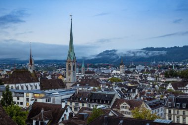 Bir Avrupa şehrinde Katolik Kilisesi saat kulesi. Huysuz ışık, yaz sabahı, yüksek görüş açısı, insan yok.